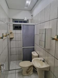 a bathroom with a toilet and a sink at Casa em Ubatuba perto da praia in Ubatuba +8 photos