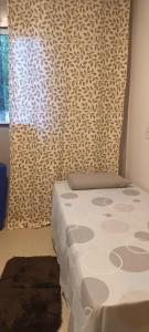 una camera da letto con un letto e una finestra con una tenda di casa por temporada pontal da barra a Maceió Altre 33 foto