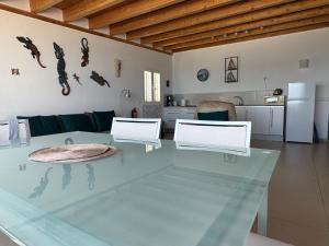 科拉雷侯Vivienda Vacacional Casa Lina的一间带玻璃桌的客厅和一间厨房
