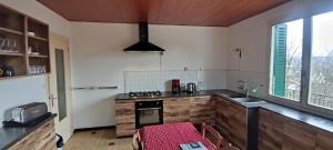 a kitchen with a stove and a sink and a table at Gîte grande capacité au calme circuit Cascades du Hérisson in Bonlieu