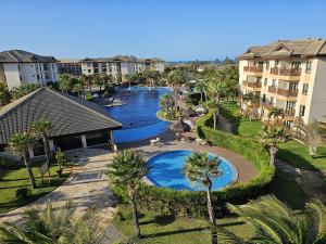 an aerial view of a resort with two pools and palm trees at VG Sun Cumbuco by TP Flats in Cumbuco