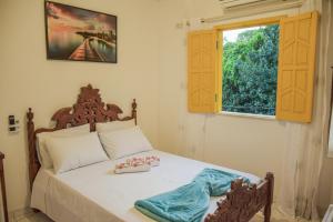 Un dormitorio con una cama con dos toallas encima. en Pousada Canto dos Pássaros, en Lençóis