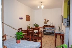 a dining room with tables and chairs and a kitchen at Pousada Canto dos Pássaros in Lençóis
