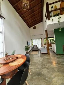 a living room with a wooden table and chairs at Casa Recanto das arvores in Itacaré