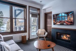 een woonkamer met open haard en tv bij Suite with mountains view & Resort access in Lac-Superieur