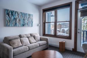 een woonkamer met een bank en een raam bij Suite with mountains view & Resort access in Lac-Superieur +30 foto's