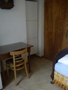 1 dormitorio con escritorio y silla junto a la cama en Privatzimmer Guckler, en Colonia