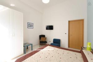 a bedroom with a bed and a chair and a television at Casa Martina in Pescara