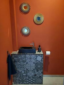 a bathroom with a sink and two mirrors on the wall at Maison de vacances la campagne in Dalhem +15 photos