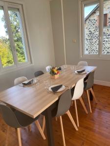 a large wooden table in a room with chairs at La Maison Lilas in Messeix +10 photos