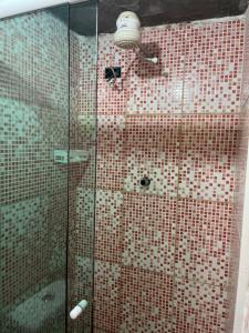 a shower with red and white tile on the wall at Pousada Casa do Nilo in Ilha do Mel
