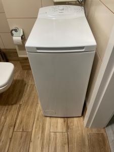 - białą lodówkę w łazience z toaletą w obiekcie Apartament Rynek Sienny 1 w Szczecinie