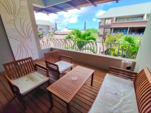 a balcony with two chairs and a table and a view at Tropical Elegance - Appartement in Grand Baie
