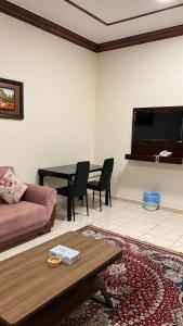 a living room with a couch and a table at منازل القمه للشقق المخدومه in Tabuk