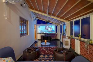 a small living room with a tv and a couch at Rosedale Farmhouse-2Acre-Pvt Pool-Jacuzzi in Talai