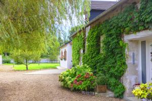 een gebouw met groene klimop aan de zijkant bij Ferme de Marpalu in La Ferté-Saint-Cyr