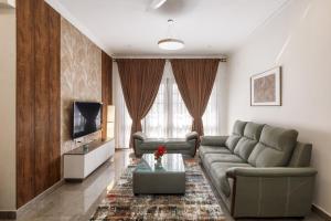 a living room with a couch and a tv at Emerlad Apartment 201 Nr MG Road Housekeeping in Bengaluru