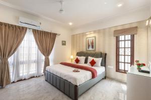 a bedroom with a large bed and windows at Emerlad Apartment 201 Nr MG Road Housekeeping in Bengaluru