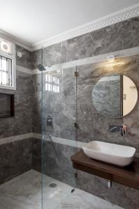 a bathroom with a sink and a glass shower at Emerlad Apartment 201 Nr MG Road Housekeeping in Bengaluru