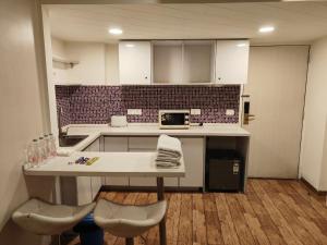 a kitchen with a table and chairs in a room at Rajhansh Belliza Nest - A Luxury 2BHK Apartment in Surat +22 photos