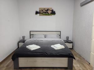 a bedroom with a bed with two towels on it at Casa Orhideea in Borsec