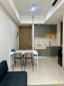 a kitchen with a white table and two chairs at Cozy Apartment connected to mall by Lexington in Jakarta +31 photos