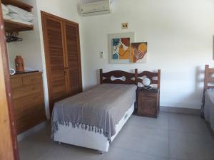 a bedroom with a bed and a wooden dresser and a bed sidx sidx sidx at Casa CANTIN DO ACONCHEGO na Praia de Taperapuan, Porto Seguro in Porto Seguro +44 photos