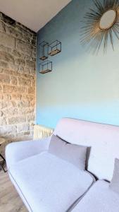 a living room with a white couch and a brick wall at La Petite Parenthèse in Beure