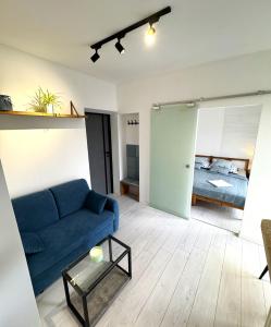 Una sala de estar con un sofá azul y una cama. en White House, en Varsovia