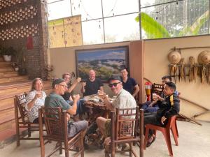a group of people sitting around a table eating at Bac Son Homestay in Bắc Sơn +28 photos