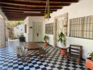 eine Veranda mit einem Tisch und Stühlen auf einem karierten Boden in der Unterkunft El cordobes in Albardón