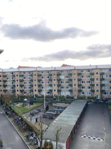 a large building with a parking lot in front of it at Central cozy apartment in Amager in Copenhagen