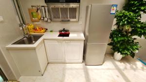 eine kleine Küche mit Kühlschrank und Spüle in der Unterkunft Shanghai Hills & Aromahome Modern Cottage Home Retreat with 2Bedrooms close to Tianzifang in Shanghai
