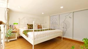 ein Schlafzimmer mit einem weißen Bett in einem Zimmer in der Unterkunft Shanghai Hills & Aromahome Modern Cottage Home Retreat with 2Bedrooms close to Tianzifang in Shanghai