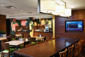 a restaurant with a large wooden table and chairs at Fairfield Inn & Suites by Marriott Omaha West in Omaha