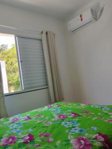ポルト・セグロにあるApartamento 2 quartos condomínio com piscinaのベッドルーム1室(花の緑の毛布付きベッド1台付)