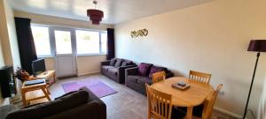 ein Wohnzimmer mit Sofa und Tisch in der Unterkunft Sand Bay, Perranporth in Perranporth