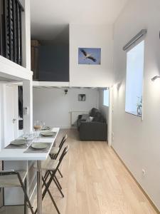 a dining room and living room with a table and chairs at Appartement proche gare in Sélestat