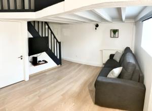 a living room with a couch and a tv at Appartement proche gare in Sélestat +15 photos