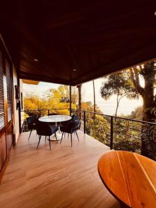 a patio with a table and chairs on a balcony at Villa SOLENSSE in Uvita