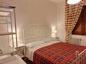 a bedroom with a bed with a red plaid blanket at B&B Da Nonna Lucia in Roccascalegna