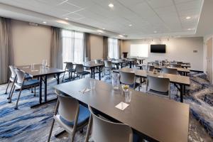 a conference room with tables and chairs and a screen at Fairfield Inn & Suites by Marriott Tampa Wesley Chapel in Wesley Chapel +17 photos