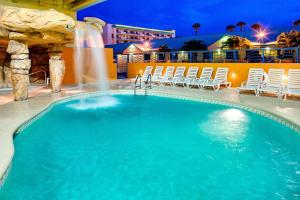ein Swimmingpool in einem Resort bei Nacht in der Unterkunft Four Points by Sheraton Cocoa Beach in Cocoa Beach