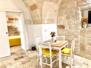 a table and chairs in a room with a stone wall at Antica Pietra in Polignano a Mare