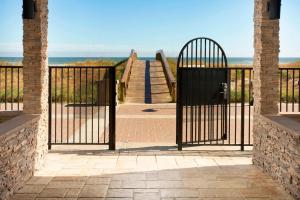 an open gate with a view of the beach at Four Points by Sheraton Jacksonville Beachfront in Jacksonville Beach +16 photos
