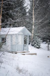 a small white shed in the snow with trees at Villa Bessberget in Edsbyn