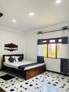 a bedroom with a bed and a large window at The Off Road Homestay in Kandy