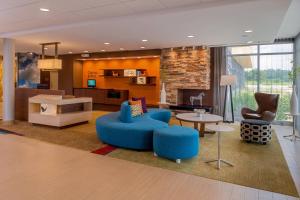 een woonkamer met blauwe stoelen en een bank en een tafel bij Fairfield Inn & Suites by Marriott Huntington in Huntington