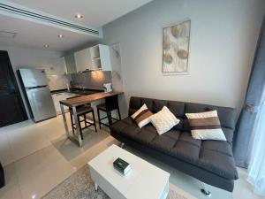 a living room with a couch and a table at Emerald Terrace Condo 10-Family One Bed & Sofa Bed Garden View in Patong Beach