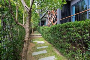 a tree with a stepping stone path next to a building at Emerald Terrace Condo 10-Family One Bed & Sofa Bed Garden View in Patong Beach